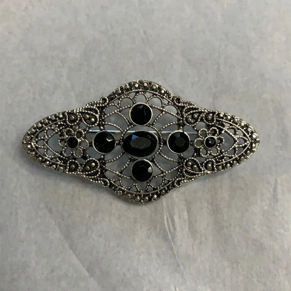 Silver and black brooch